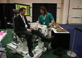 Justin Miller of Marine Corps Systems Command tests a subject's leg strength during the Navy League's Sea-Air-Space Exposition...